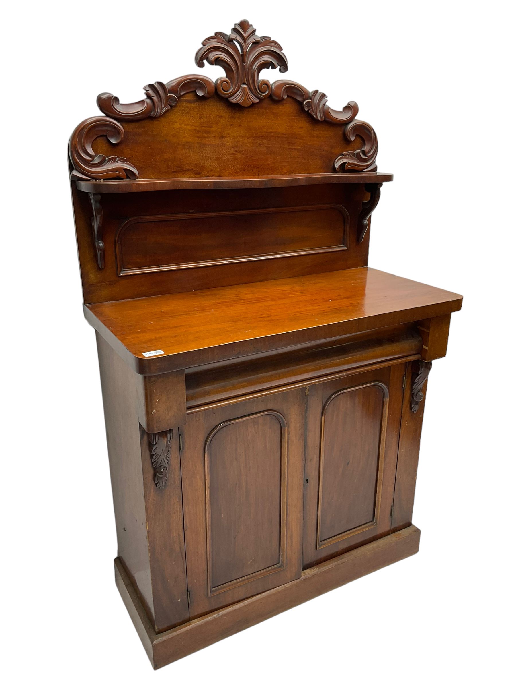 Victorian mahogany chiffonier, raised back with carved C-scroll foliage mounts and shelf, rectangular top with rounded corners over frieze drawer and double panelled cupboard, on skirted base