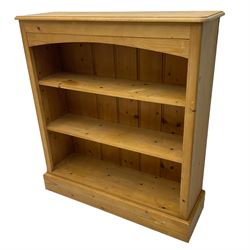 Pine open bookcase, fitted with two adjustable shelves, on plinth base
