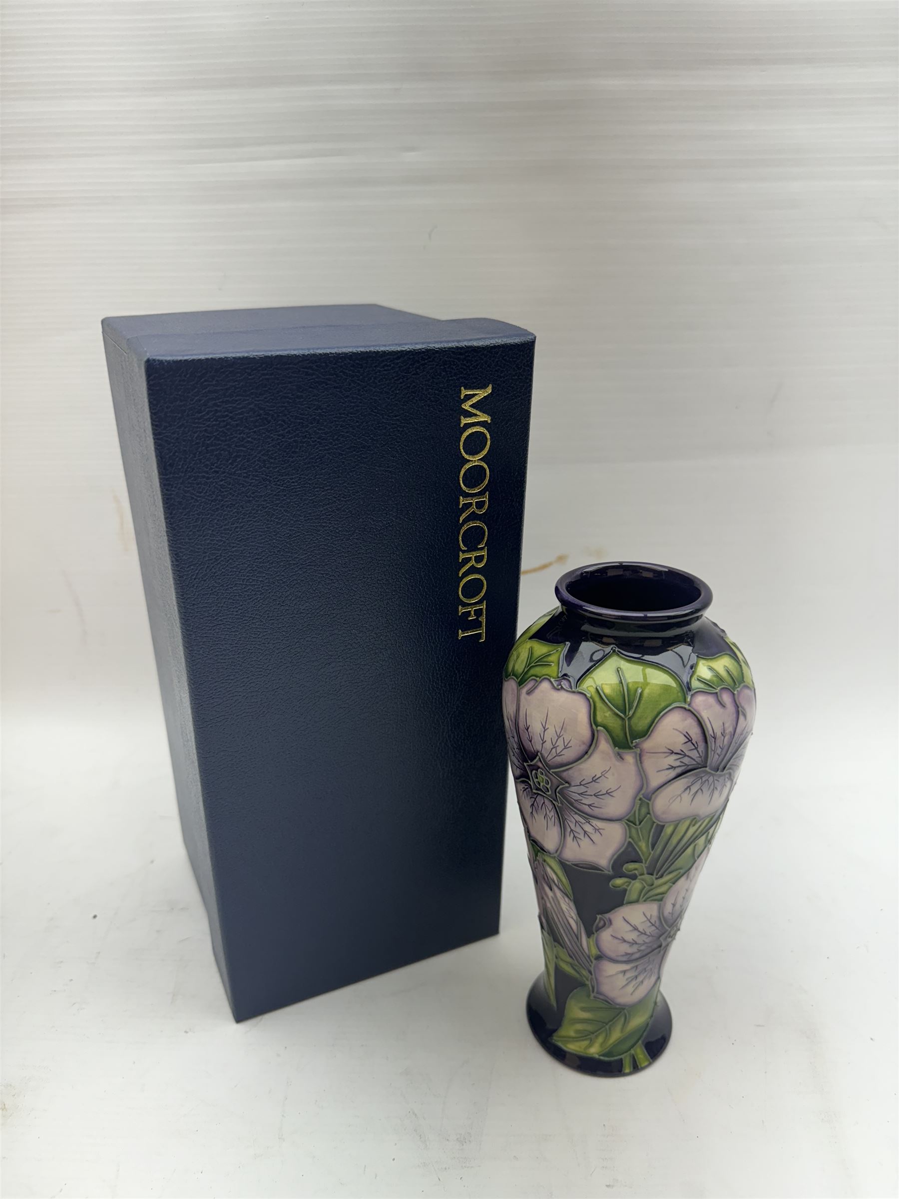 Moorcroft vase in Petunia pattern upon a purple ground, of tall baluster form, marked made for collectables to the base,  with original box, H21cm