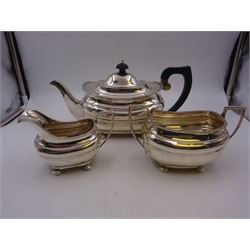 Silver three piece tea service, comprising teapot, twin handled open sucrier and a milk jug, all of oval part fluted form and upon four bun feet, the teapot with black plastic handle and finial, hallmarked S Blanckensee & Son Ltd, Chester 1930, teapot H16cm