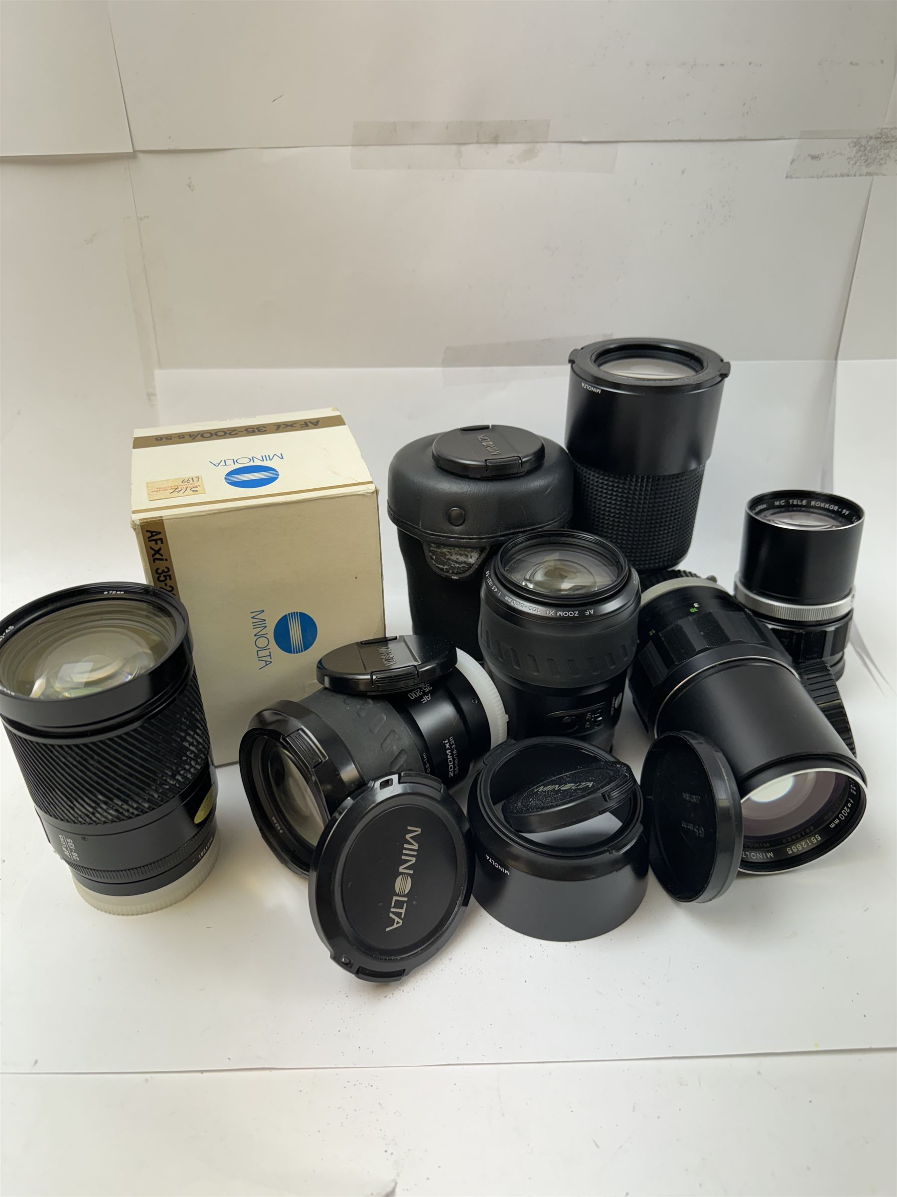 Six Minolta camera lenses, to include AF xi 35-200/4.5-5.6 serial no. 21148974, boxed, AF Zoom Xi 100-300mm 1:4.5(32)-5.6 lens serial no. 32205497, AF Zoom 28-135mm 1:4(22)-4.5 lens serial no. 1001096, MC Tele Rokkor-QF 1:3.5 f=200mm lens serial no. 5512665, MD Zoom 70-210mm 1:4 lens serial no. 1056195 and an MC Tele Rokkor-PF 1:28 f=135mm lens serial no. 1173532