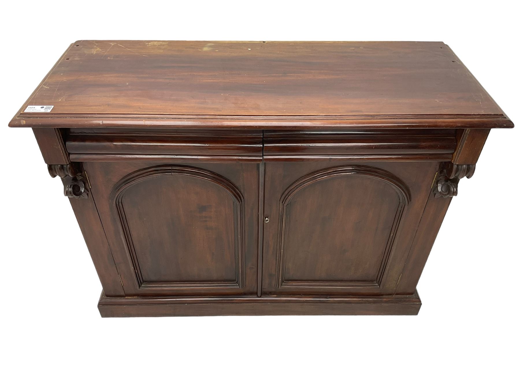 Victorian mahogany chiffonier, raised shaped back with foliage scroll carved mounts, on fretwork and carved bracket supports, moulded rectangular top over two frieze drawers and double panelled cupboard, on moulded plinth base