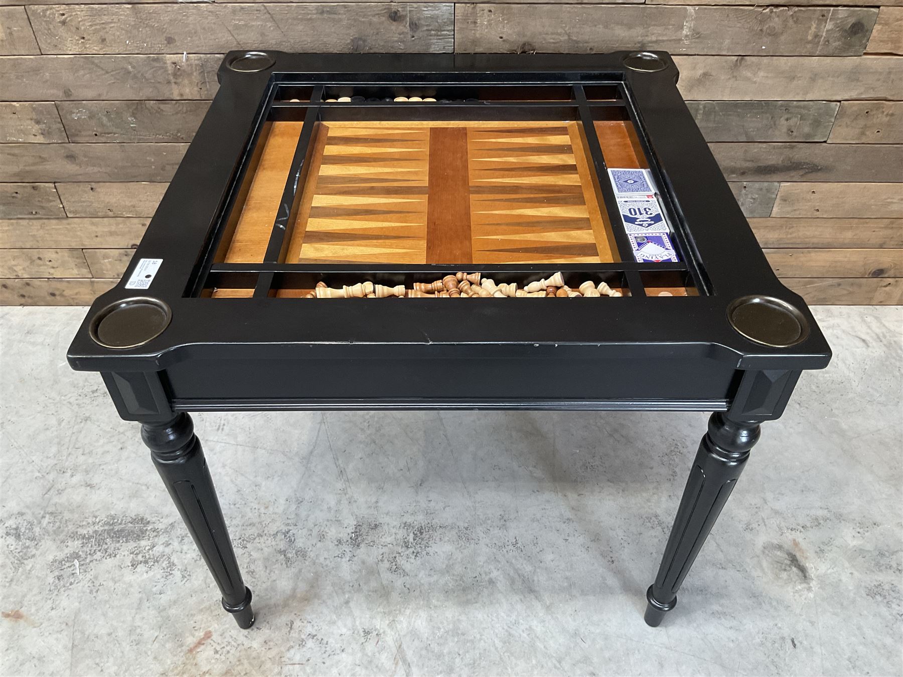 Ebonised square games table, reversible chessboard top revealing games compartment