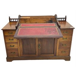 Victorian walnut clerk's desk, raised central section with tambour roll over hinged top, the interior fitted with leather inset writing surfaces, small drawers, document divisions and pen and ink stand, central drawer over double panelled cupboard, flanked by two banks of four graduating drawers, on bracket feet 