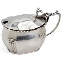 George III silver cream jug with later embossed decoration London 1797 Maker Thomas Meriton and a silver mustard pot with blue glass liner London 1931 Maker William Comyns & Sons Ltd (2)