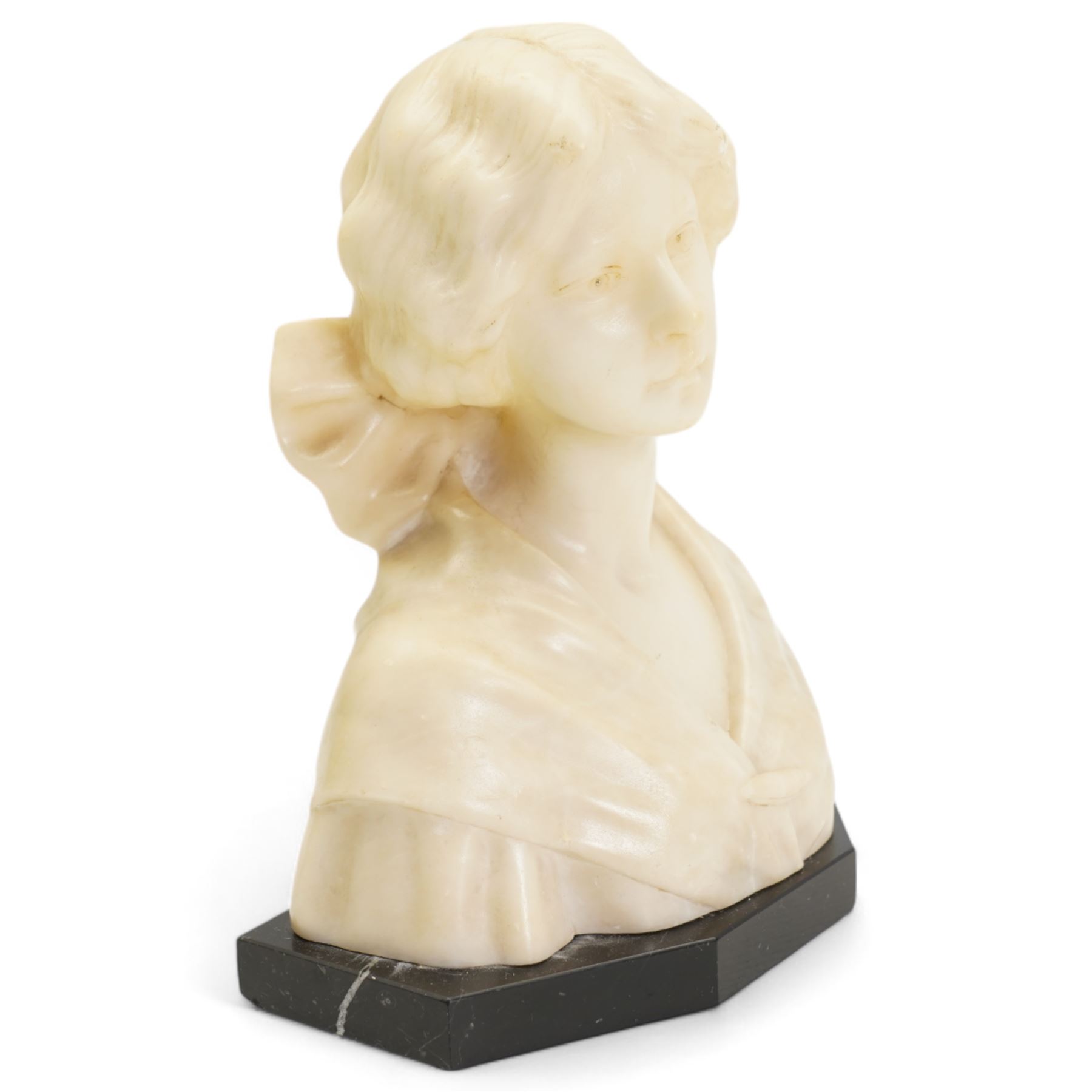 Early 20th century alabaster of a young girl, wearing a ribbon in her hair, on a black marble base, H19.5cm and another carved female bust on an ebonised base, H20.5cm (2)