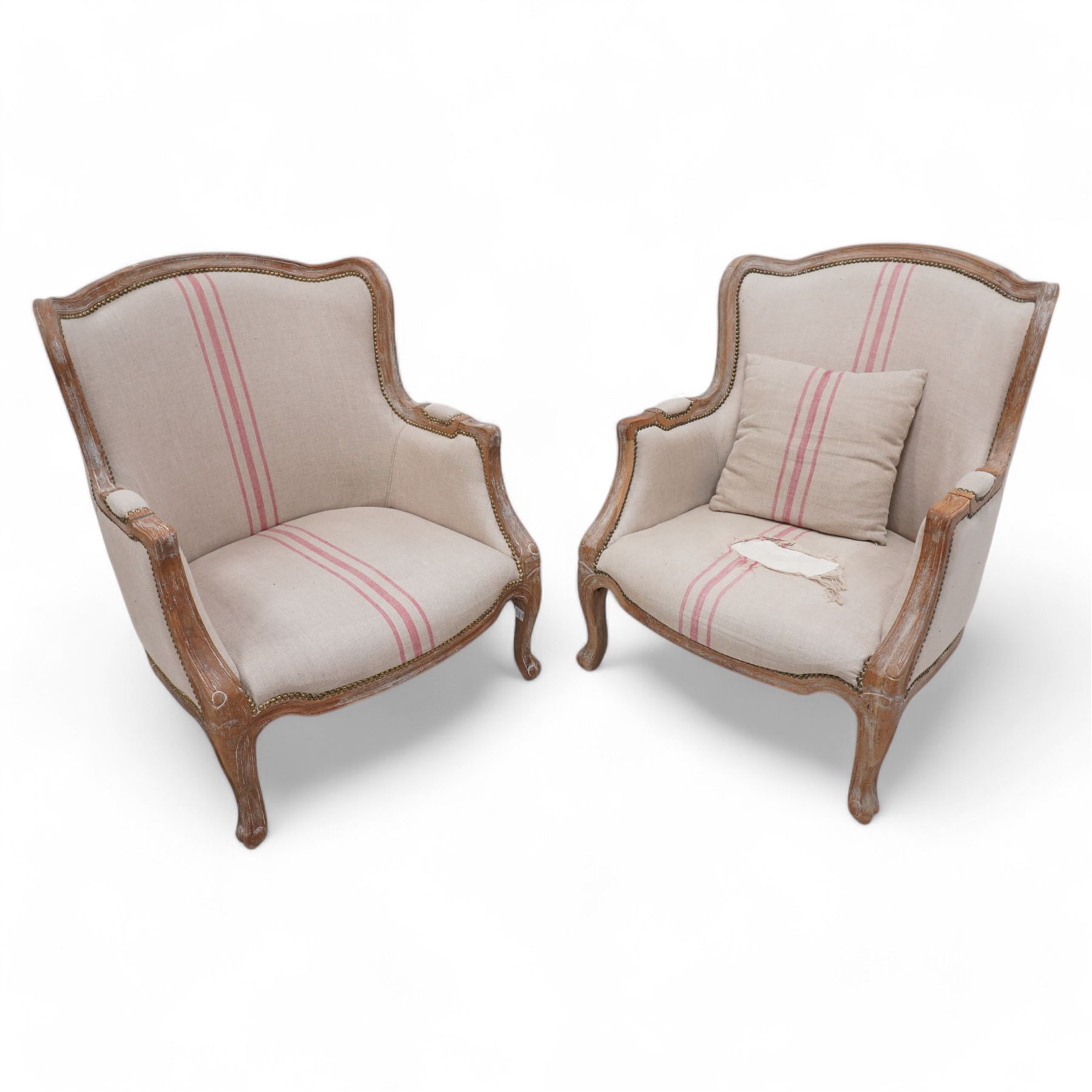 Pair of large hardwood-framed French design armchairs, moulded and shaped frames terminating to cabriole feet, upholstered in pale fabric with pink stripes 