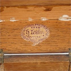 Late Victorian oak stationery box carved with Gothic and foliate panels, hinged sloping lid and divided interior with the trade label of H Ladd, 34 Trinity St. Cambridge, Stationer & Die Sinker W26cm