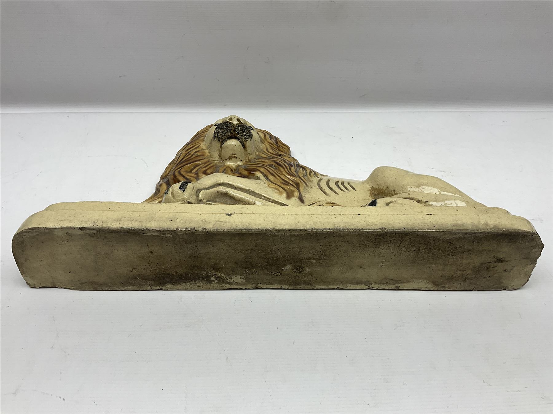 19th century salt-glazed stoneware door porter, as a recumbent lion, upon a stepped plinth base, H32