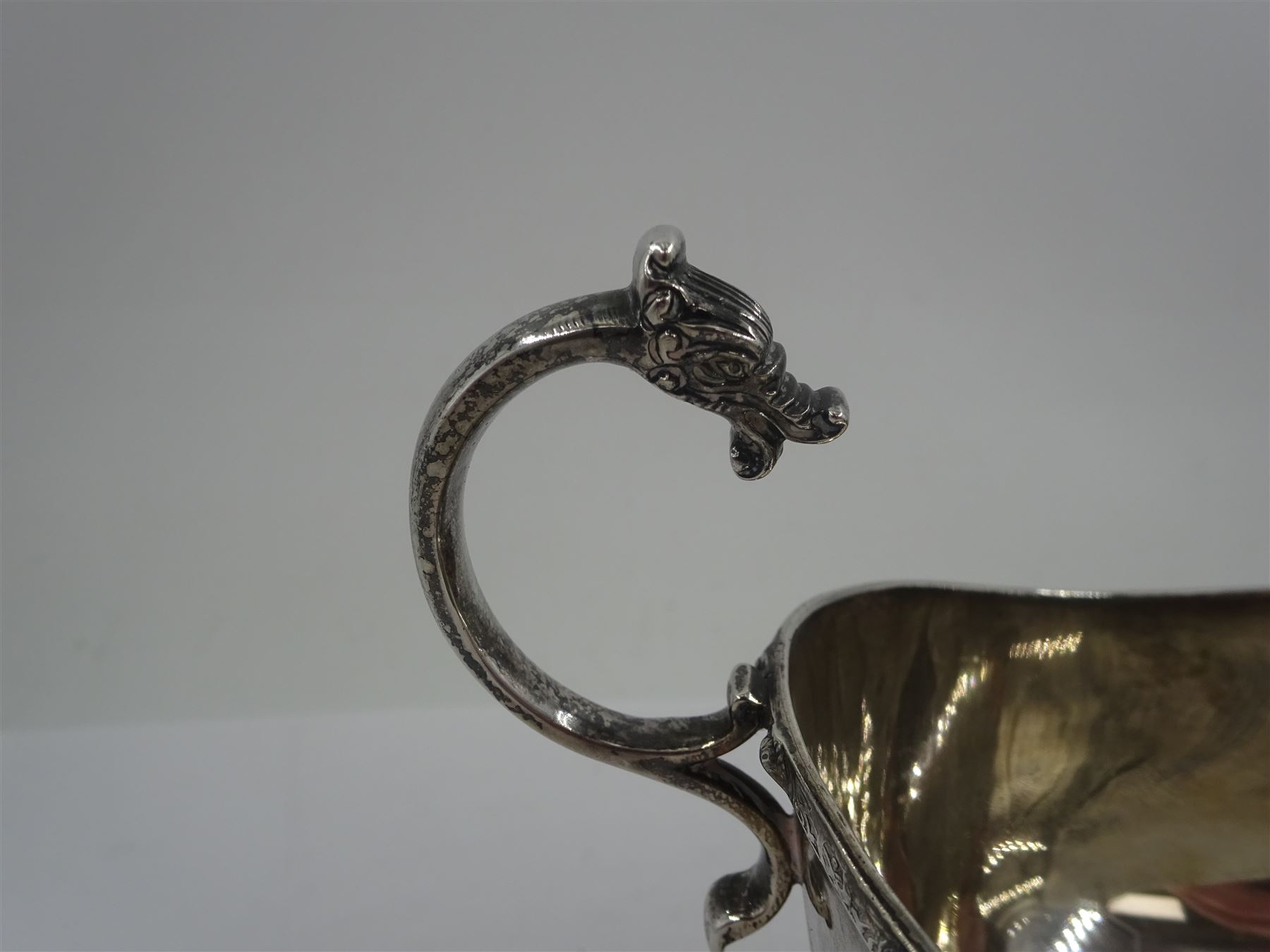 Early 20th century silver sauce boat, of typical form with flying scroll handle, the handle and feet modelled as Viking style dragon heads, hallmarked Adie Brothers Ltd, Birmingham, date mark indistinct, possibly 1940, including handle H9cm