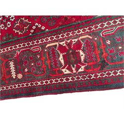 Persian Meymeh red ground rug, stepped lozenge medallion and spandrels, decorated all over with tree of life motifs, the main border decorated with repeating stylised plant motifs within geometric guard stripes 