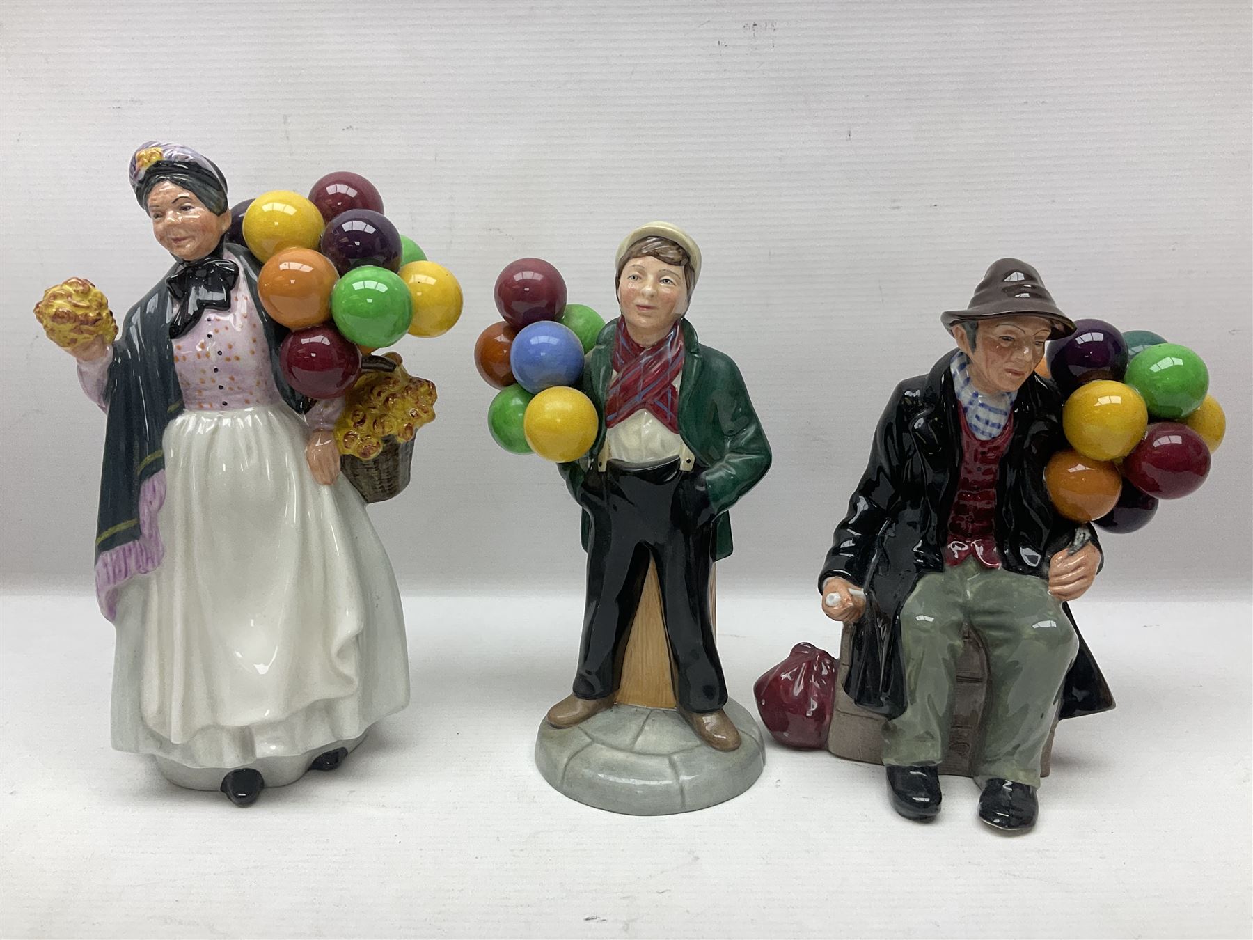 Seven Royal Doulton figures, including The Mask Seller HN2103, Silks and Ribbons HN2017, Balloon Girl HN2818, Balloon Boy HN2934 and other balloon sellers 