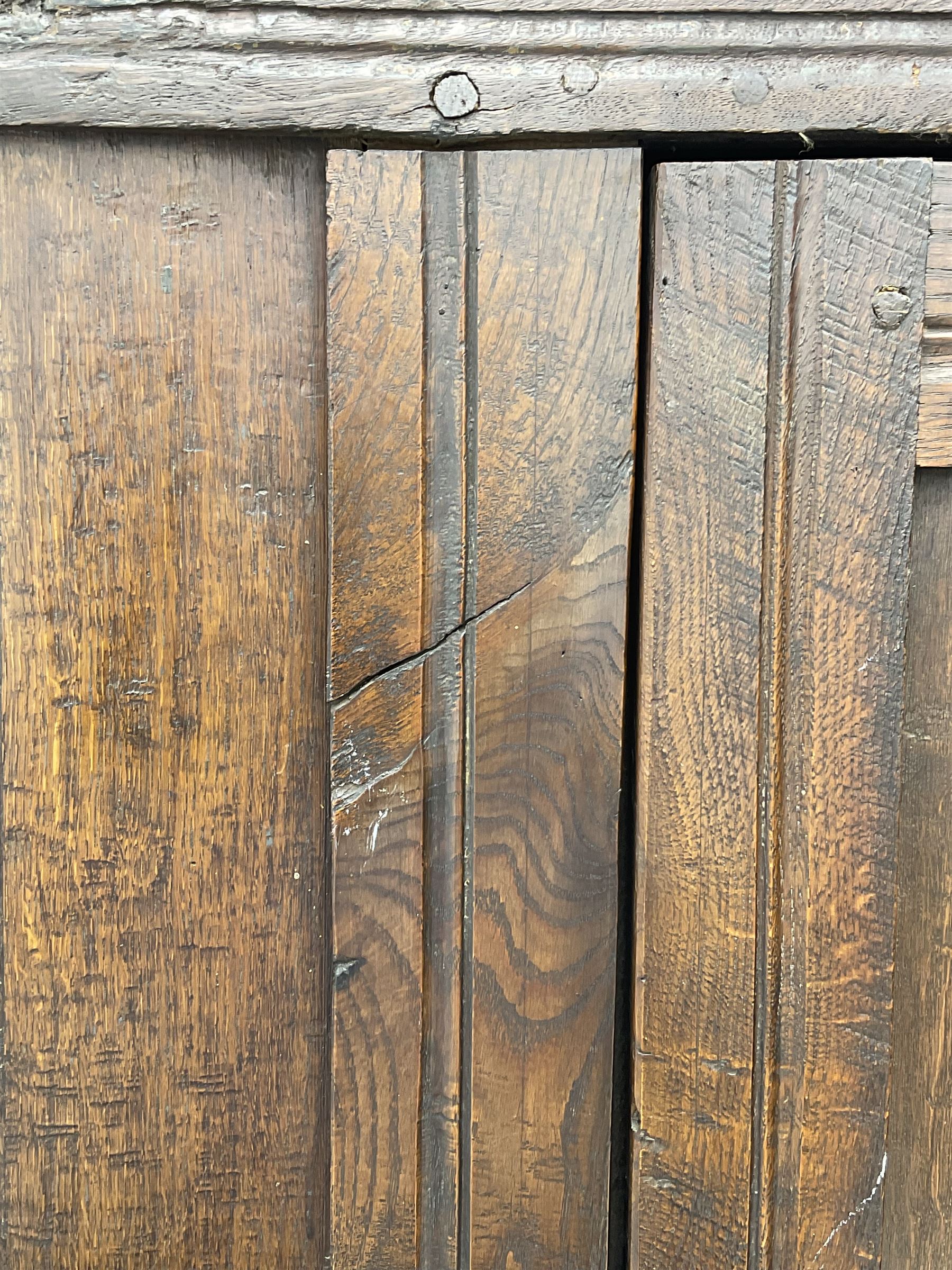 17th century and later oak hall cupboard, panelled front and sides with moulded frame, enclosed by single door with wrought metal hinges and handle, the interior fitted with hooks, on stile supports 