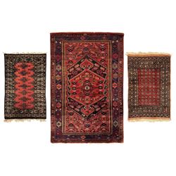 Bokhara-style wool rug, red field with black geometric motifs and intricate black borders ...