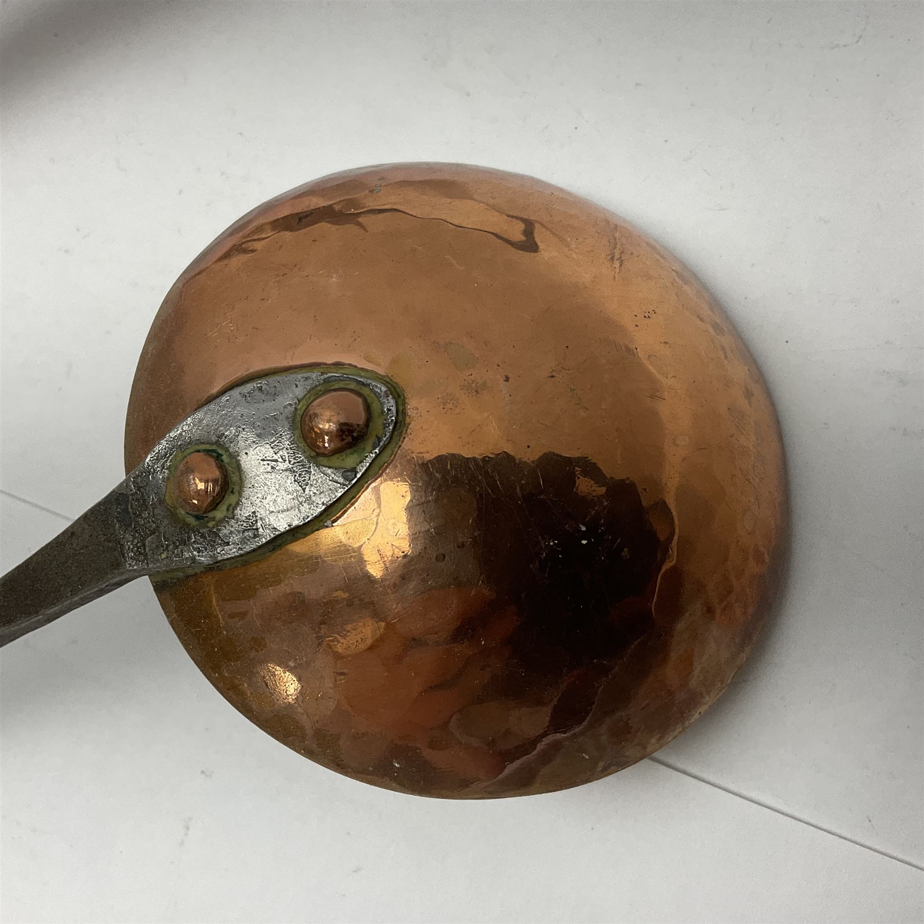 Large 19th century copper slotted spoon, with pierced flat bowl, L55cm, together with two 19th century iron handled ladles with circular copper bowls, largest example L48.5cm, (3)