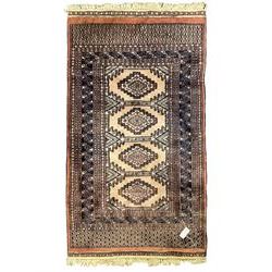 Persian peach ground rug, the field divided into four panels each with geometric lozenge, multiple band border with stylised flower head motifs, the end panels decorated with repeating lozenges