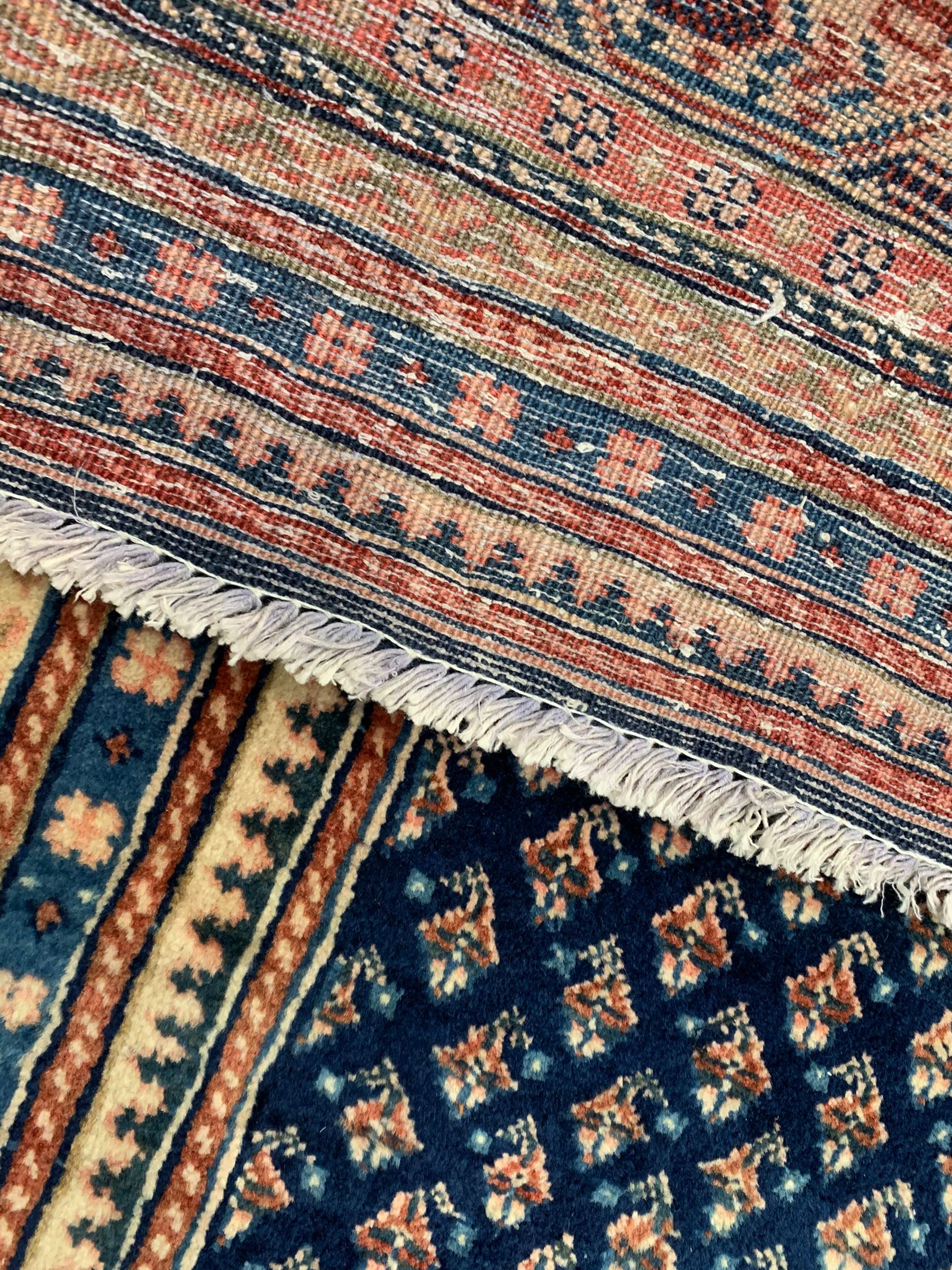 Persian Araak indigo ground carpet, the field decorated with small repeating Boteh motifs, multiple band border decorated with geometric design 