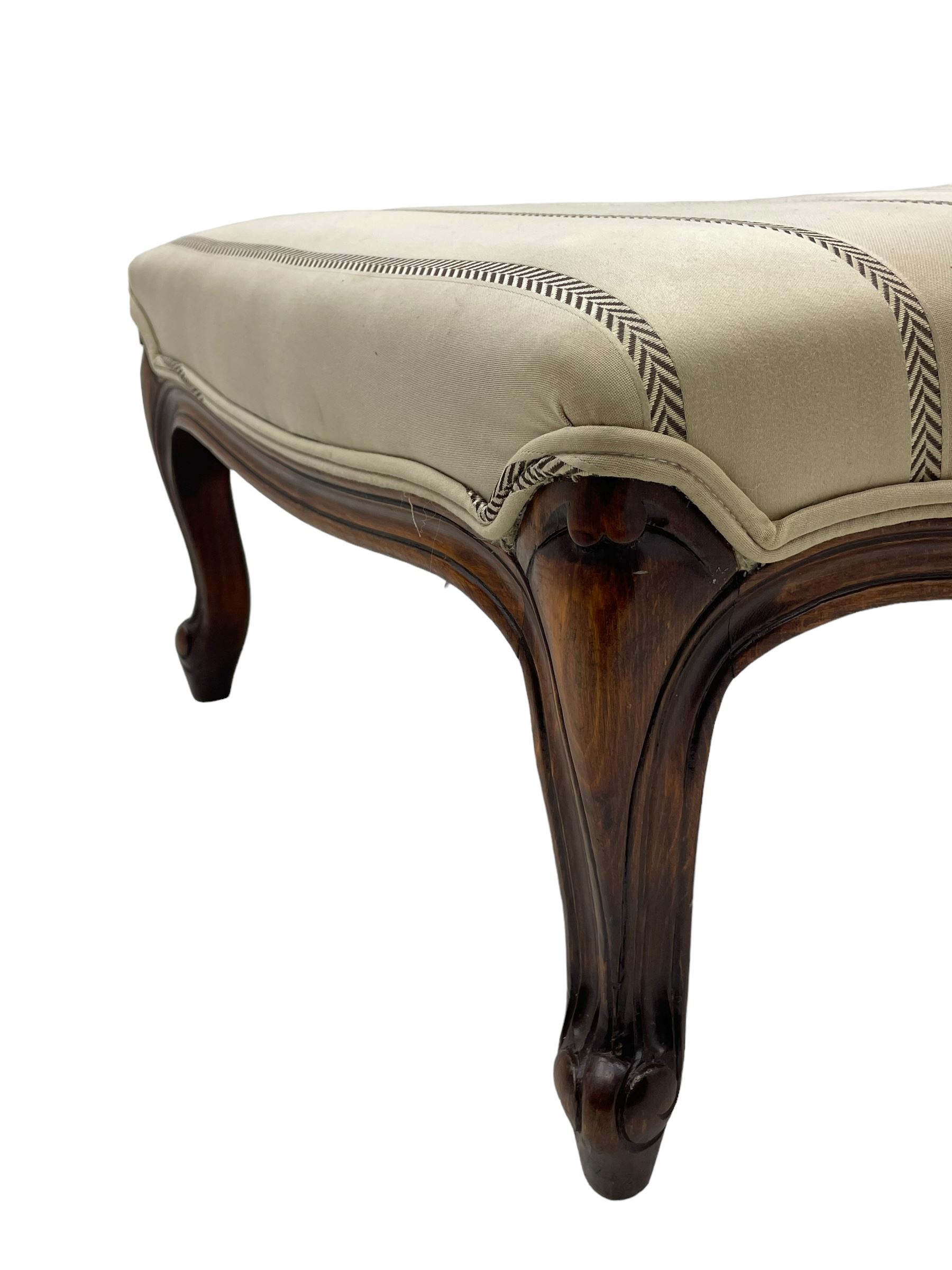 Pair of French design stained beech footstools, shaped form upholstered in pale fabric with herringbone stripe, on cabriole feet with scroll carved terminals 