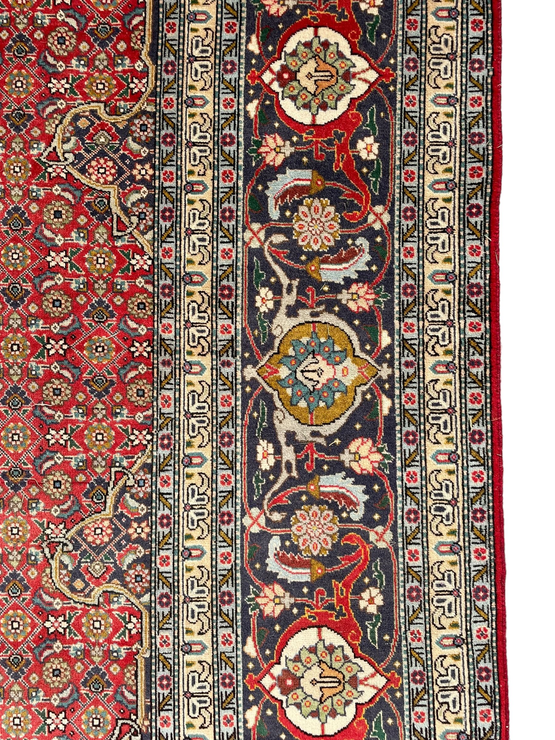 Perisian Bidjar crimson ground rug, within scalloped borders, central pole medallion, the field decorated all over with floral Herati motifs, guarded border decorated with repeating stylised plant motifs and trailing branch 