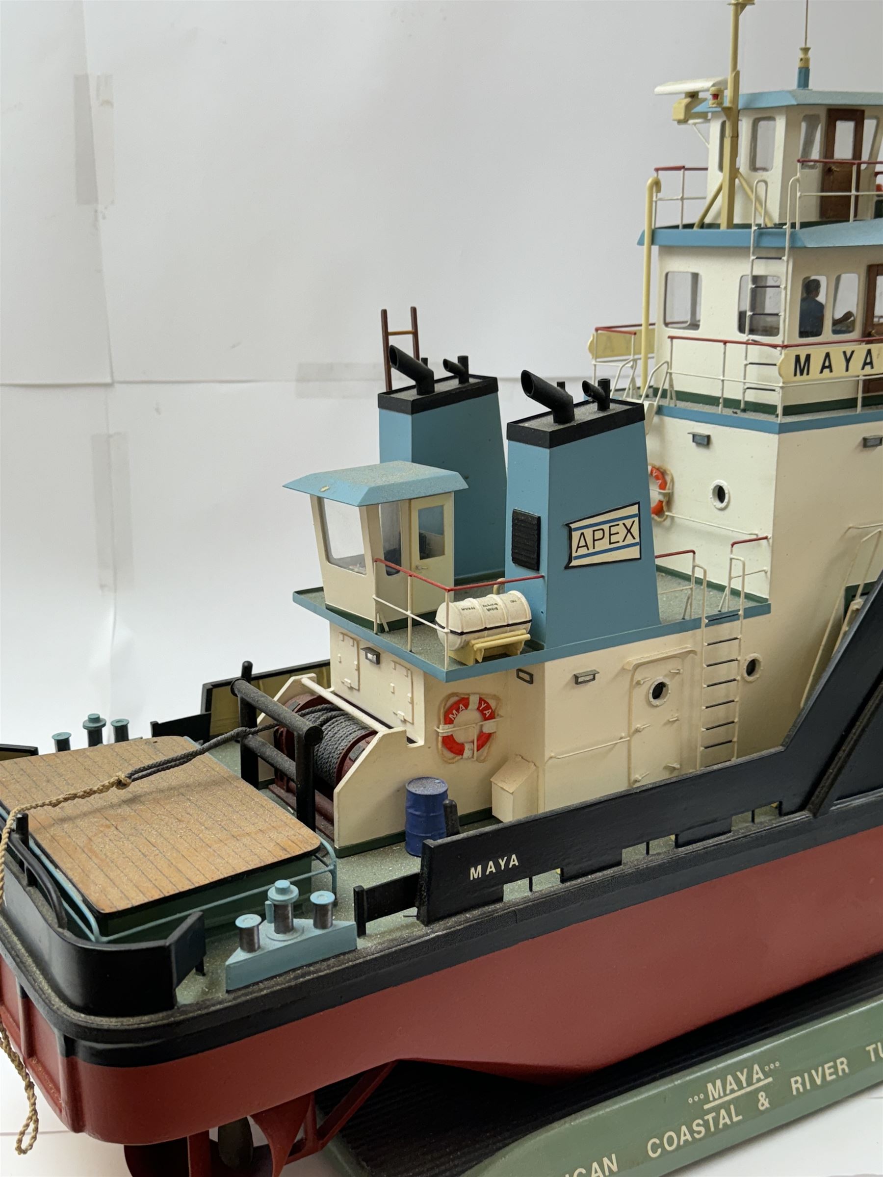 Modern model of American Coastal and River Tugboat 'Maya', in red, black and light blue finish, upon a green stand inscribed with name, H53cm, W52cm 