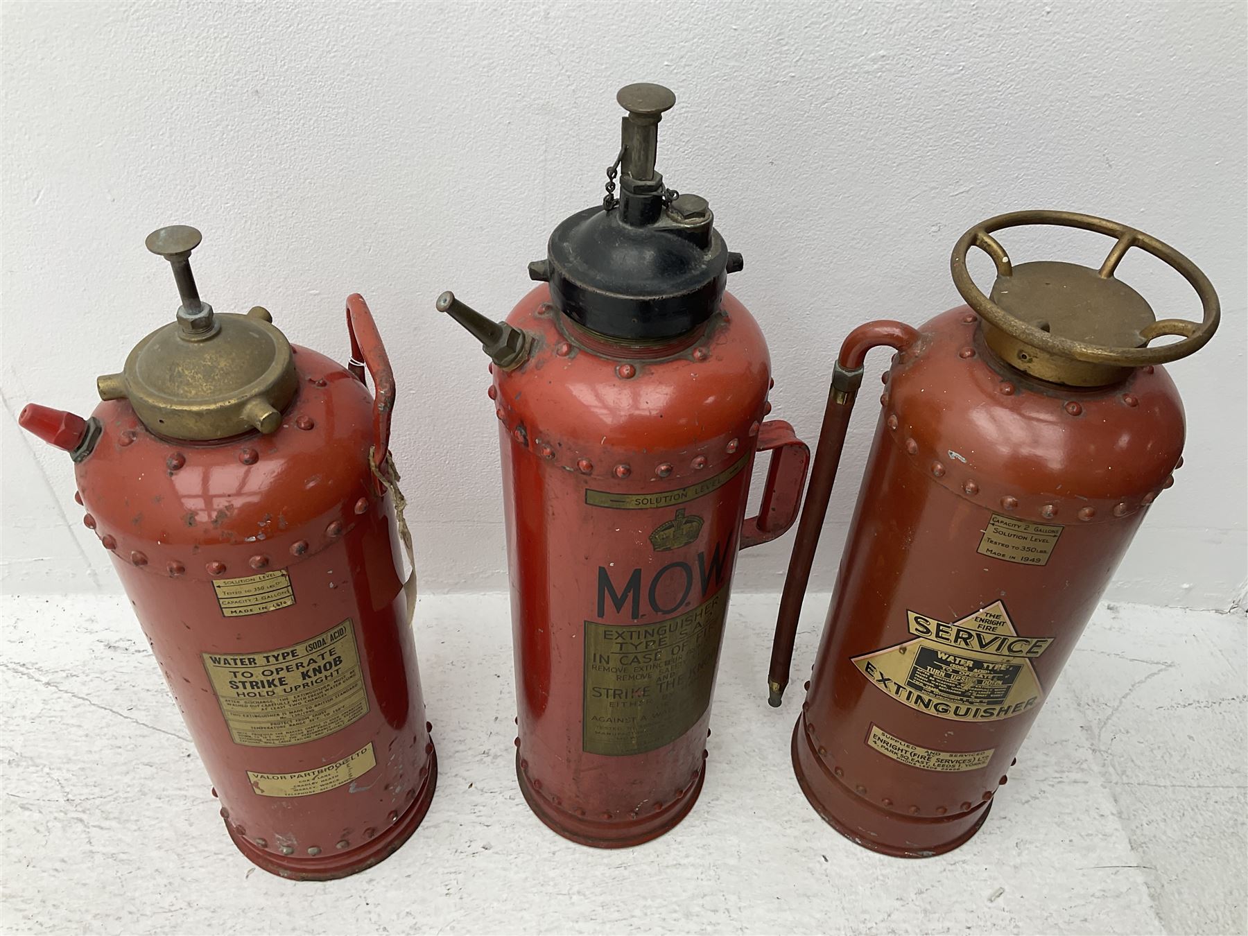 Three fire extinguishers to include an Enright Fire Services extinguisher dated 1949, a Valor Partridge Ltd. example dated 1970 and a M.O.W. example, tallest H63cm