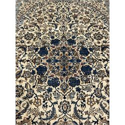 Persian ivory ground carpet, overall floral pattern with central rosette medallion, the field decorated with interlaced leafy branches and stylised plant motifs, guarded repeating border with repeating design