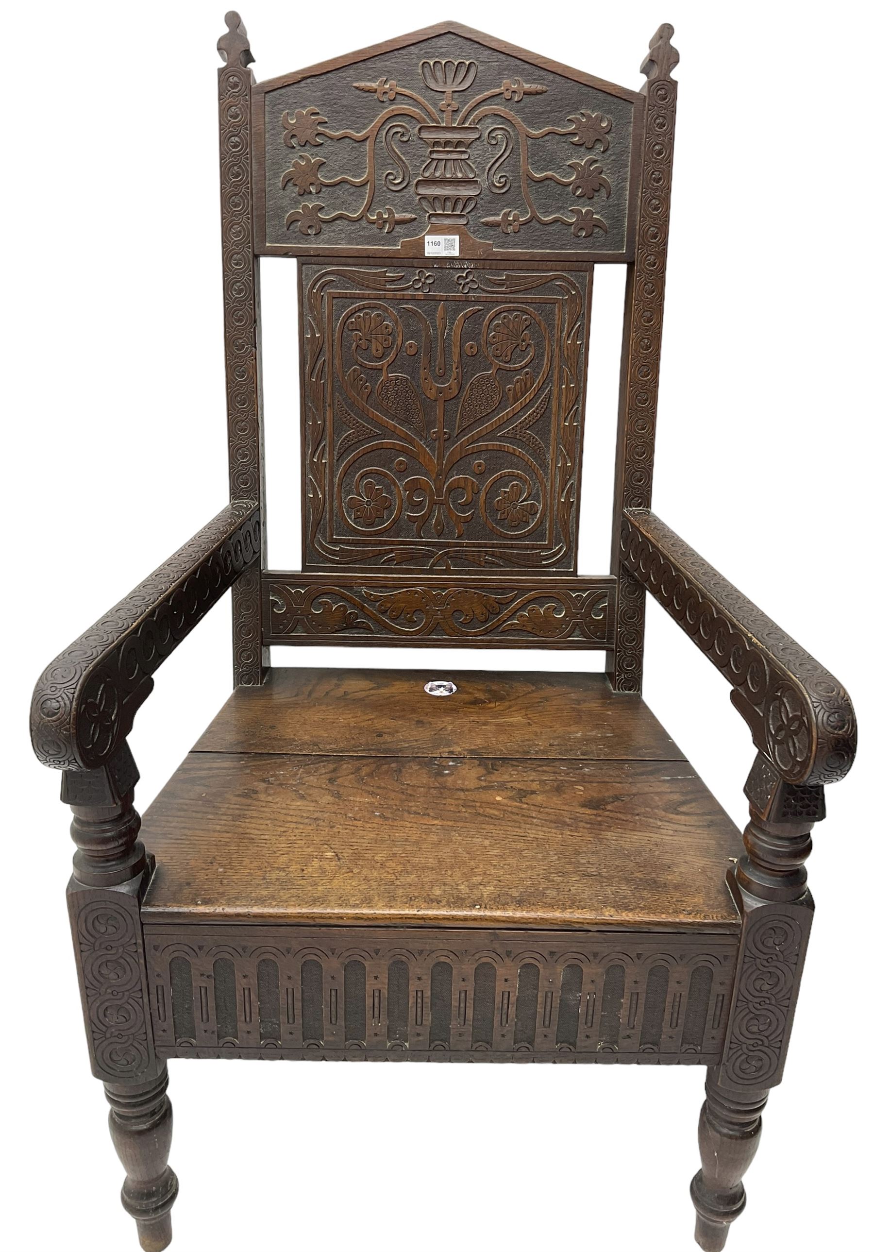 17th century design oak wainscot chair, the back profusely carved with scrolling foliate motifs, the arms carved with repeating guilloche decoration over an arcade apron and turned supports