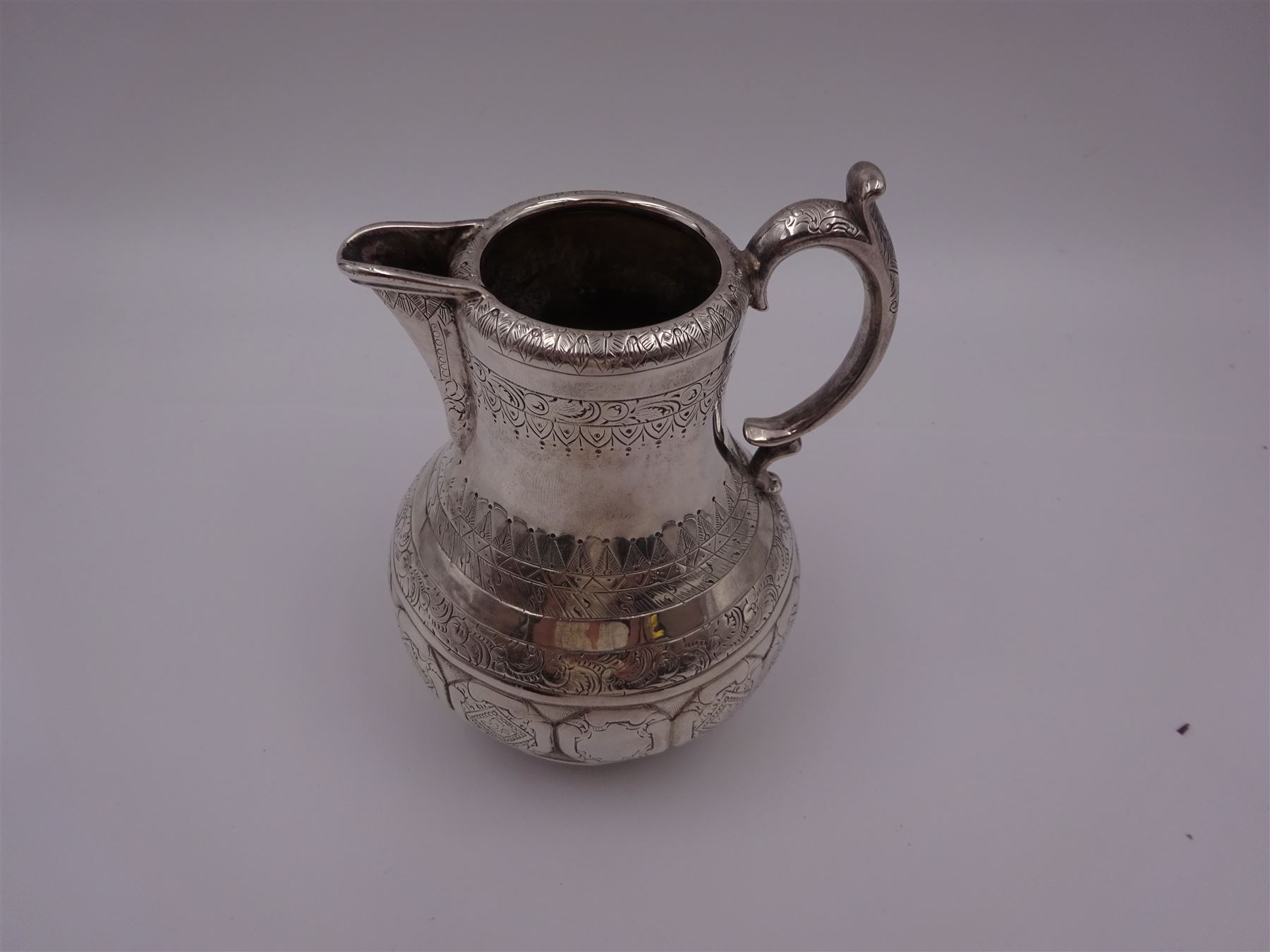 Arts and Crafts silver jug, of bellied form with C handle, the body engraved with a band of floral panels, with engraved scrolling and foliate decoration throughout, hallmarked hallmarked Samuel Smily, Goldsmiths Alliance, London 1873, H13cm