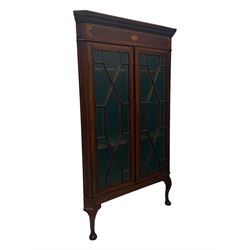 Edwardian mahogany corner cabinet, projecting cornice over inlaid frieze, two astragal glazed doors enclosing shelved interior, on cabriole supports