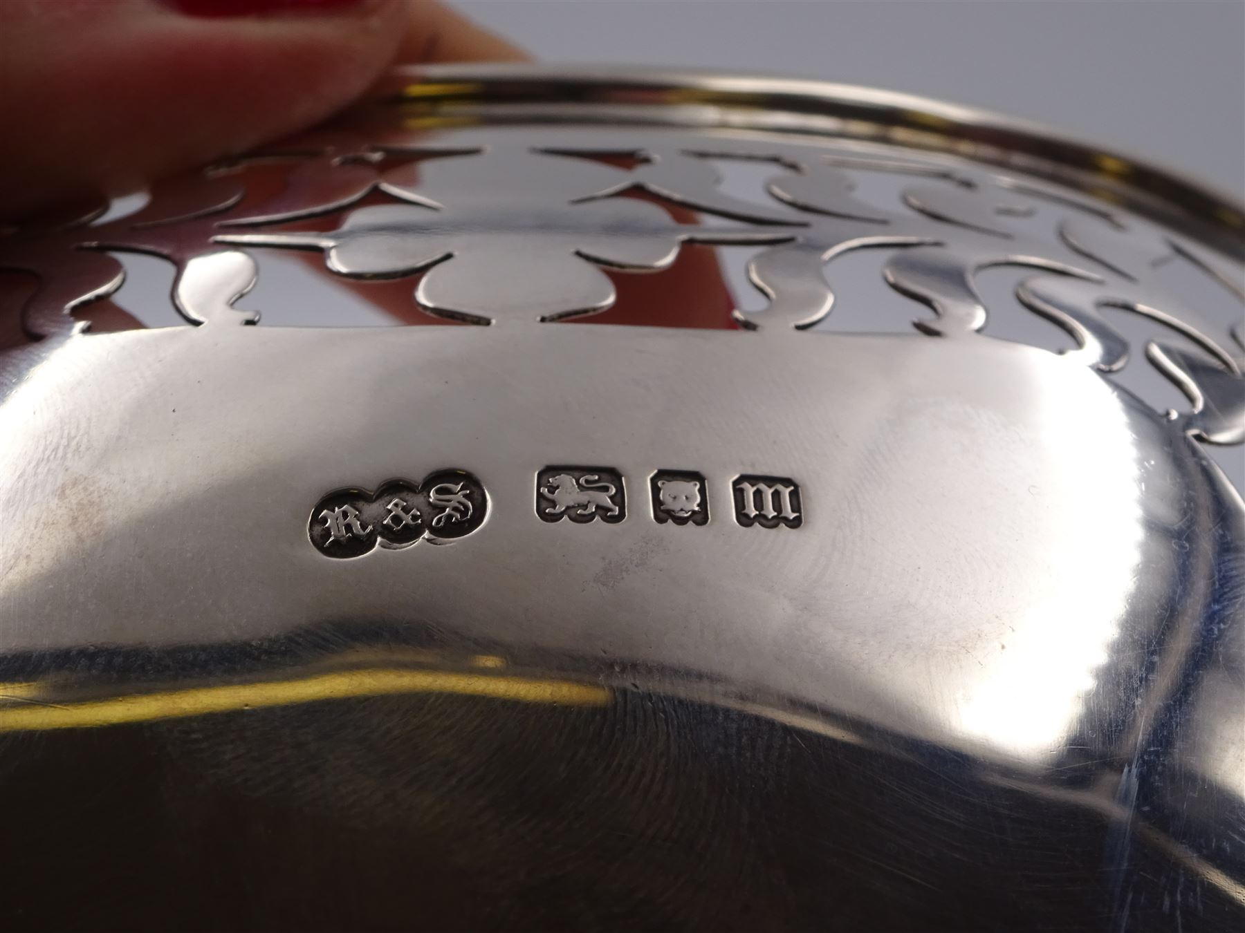 1920s silver bowl, of circular form with shaped rim, the sides with pierced foliate and floral decoration, upon four splayed feet, hallmarked Reid & Sons, London 1927, H9cm, D23cm