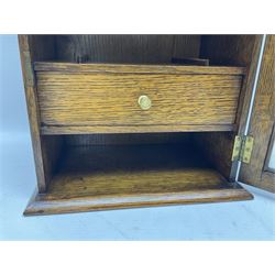 Edwardian oak smokers cabinet with the single glazed door to fitted interior having a single draw and pipe rack, H40cm