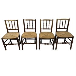 Set of four 19th century elm spindle back chairs, bar cresting rail over three turned vertical spindles, rush seat on turned supports united by turned stretchers 