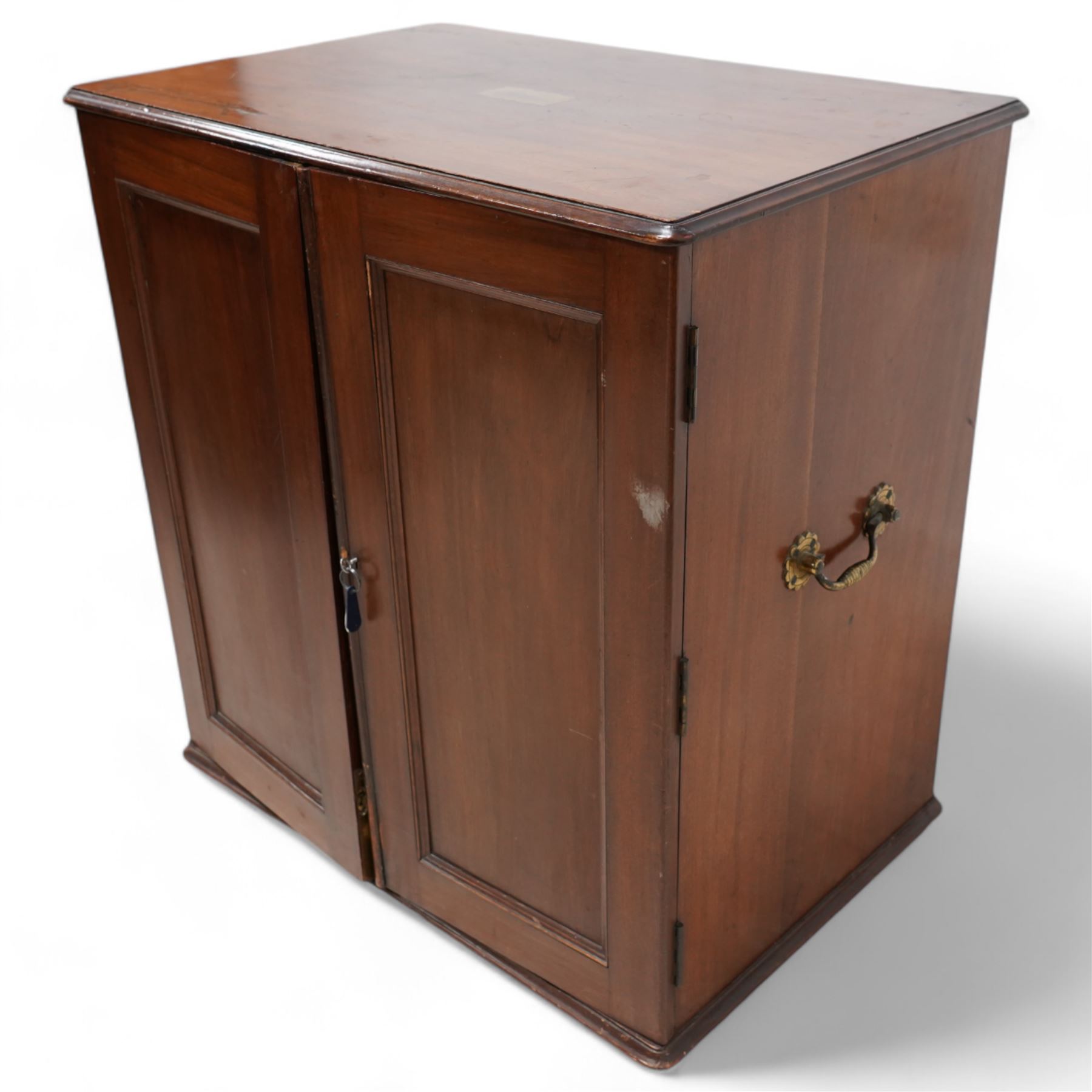 19th century mahogany silver or collectors cabinet, moulded rectangular top over two panelled doors, fitted with a combination of drawers with fitted baize lined interiors, two brass carrying handles to each side 