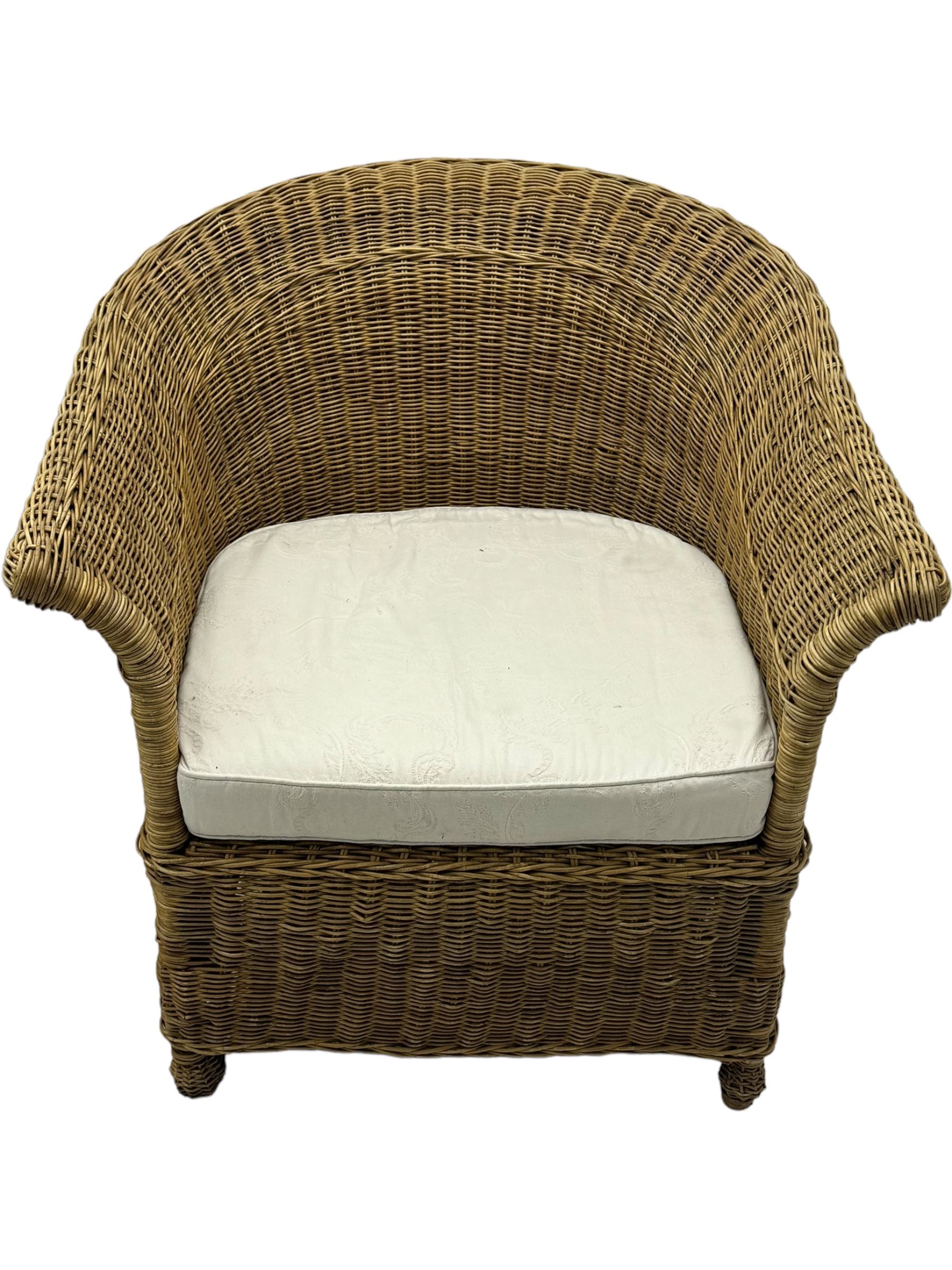 Rattan armchair and ottoman set, pair of armchairs featuring rounded backrests with wide armrests, woven wicker frame with weaving and upholstered seat cushions in off-white fabric with flowing floral pattern (W83 D80 H78cm); matching round ottoman with upholstered cushion on square wooden feet (W65 D65 H37cm)