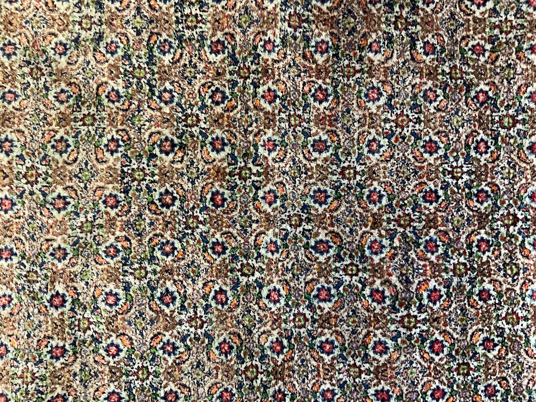 Persian indigo ground rug, the ivory field decorated with all-over flower heads, heavily guarded border with repeating stylised plant motifs