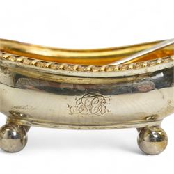 Pair of George III silver salts of elongated oval design with gilded interior and gadrooned border engraved with a monogram, raised on ball feet each 8.5cm x 6cm London 1820 Maker Rebecca Emes and Edward Barnard I together with a pair of later salt spoons