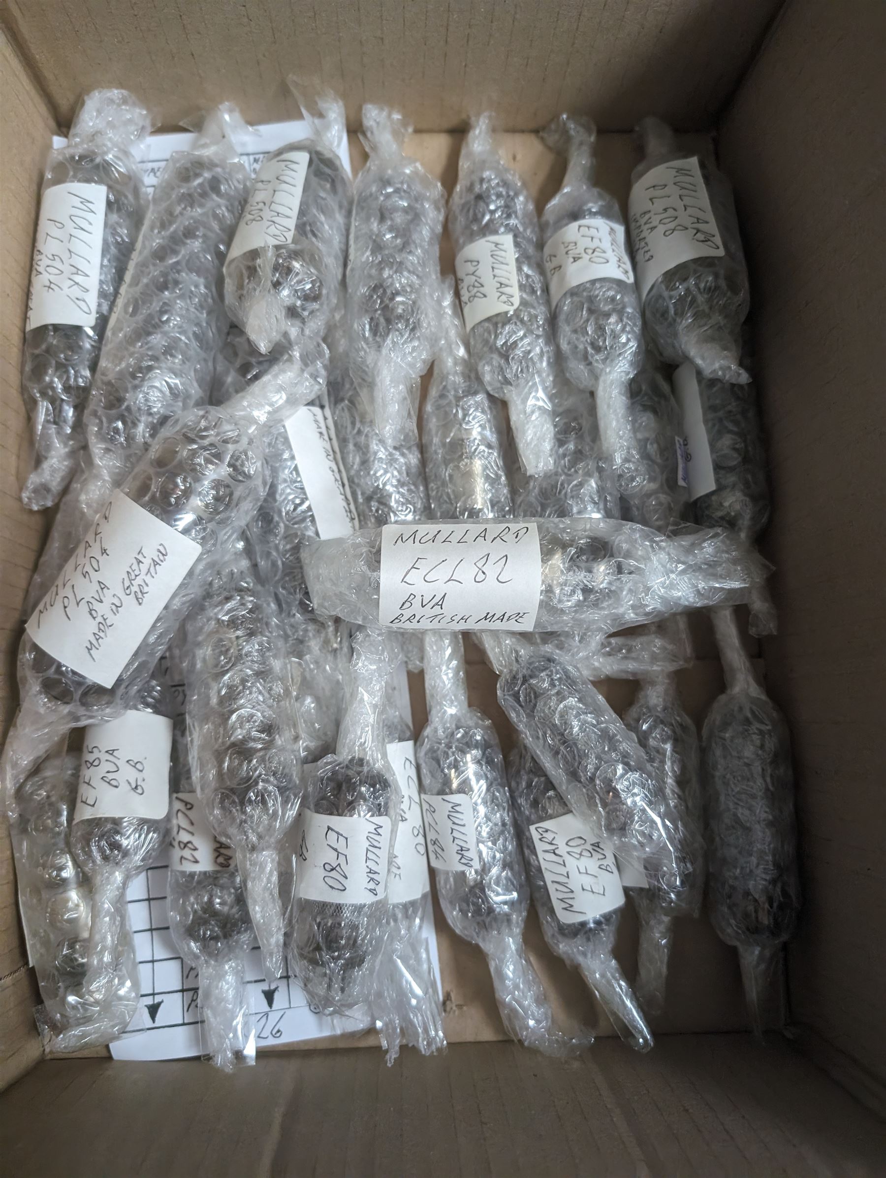 Collection of Mullard thermionic radio valves/vacuum tubes, mostly bubble wrapped and identified with lists