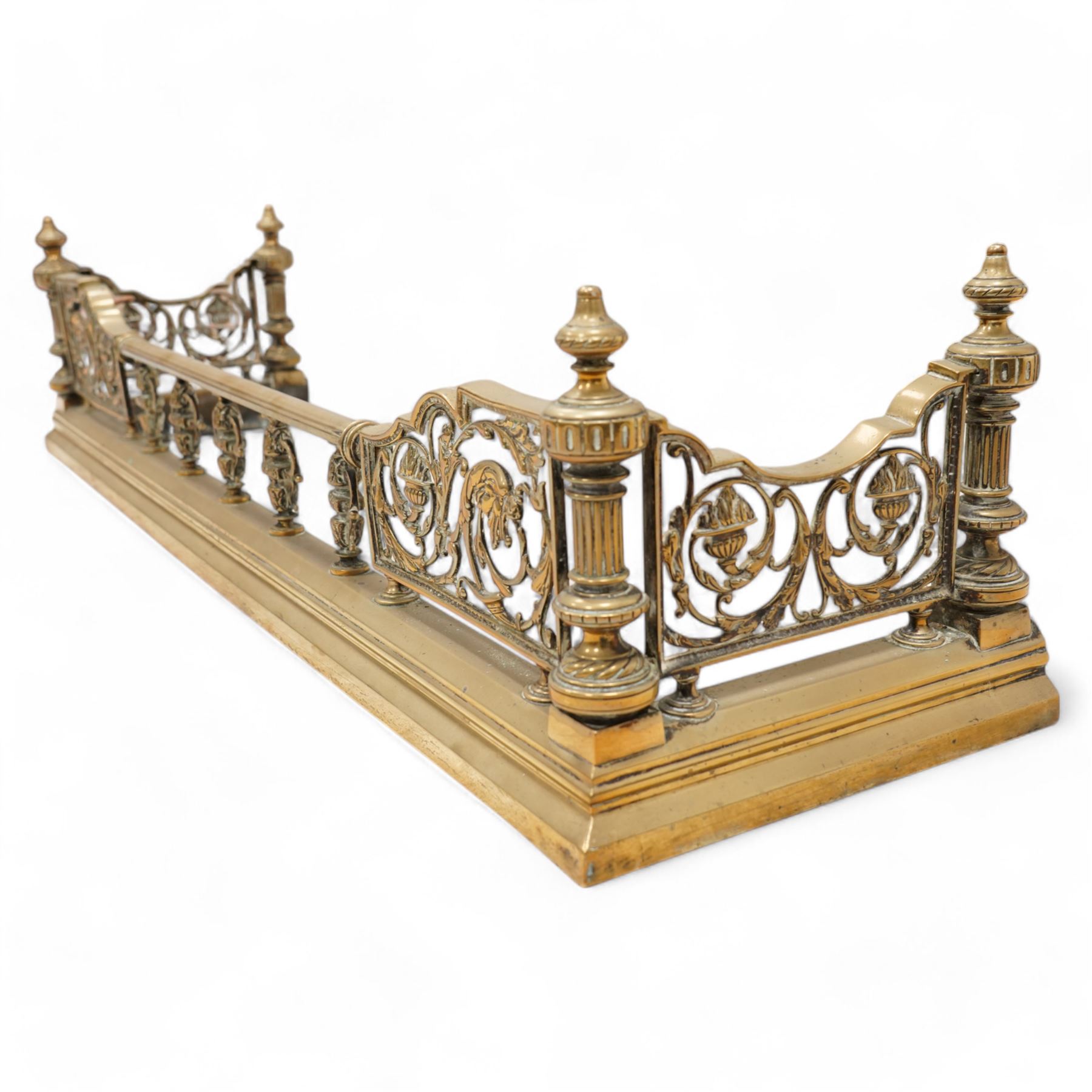 19th century brass fire fender, scrolling acanthus leaf and torch panels to the front and returns, enclosed by four reeded pillars with finials, on moulded curb base 