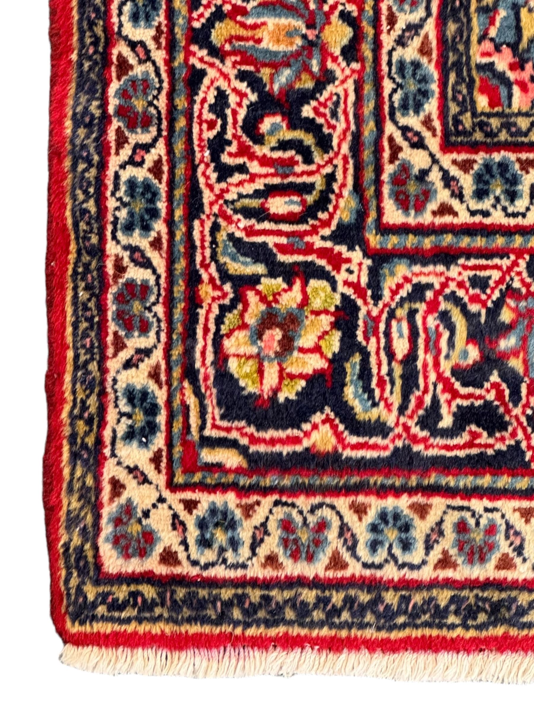 North west Persian Sarouk crimson ground rug, central floral medallion surrounded by scrolling branches decorated with foliage and stylised plant motifs, the main border decorated with repeating scrolling design with floral motifs, within guard stripes 