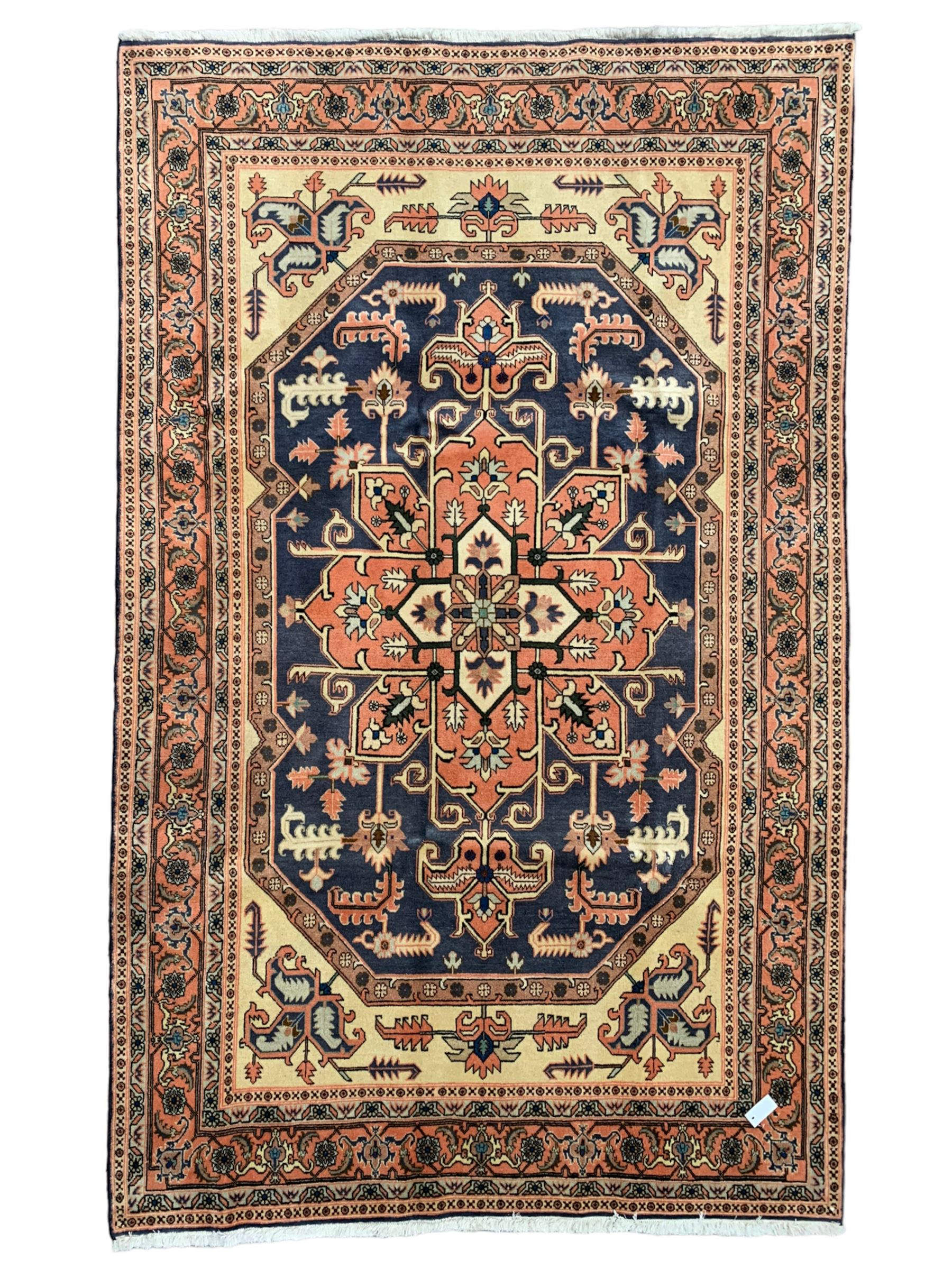 Persian ivory and peach ground, overall geometric design, the field with central star medallion surround stylised leaf motifs, guarded geometric design border