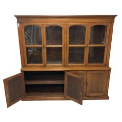 Mid-to-late 20th century Burmese teak wall cabinet, four glazed doors over four panelled doors, on moulded plinth base 