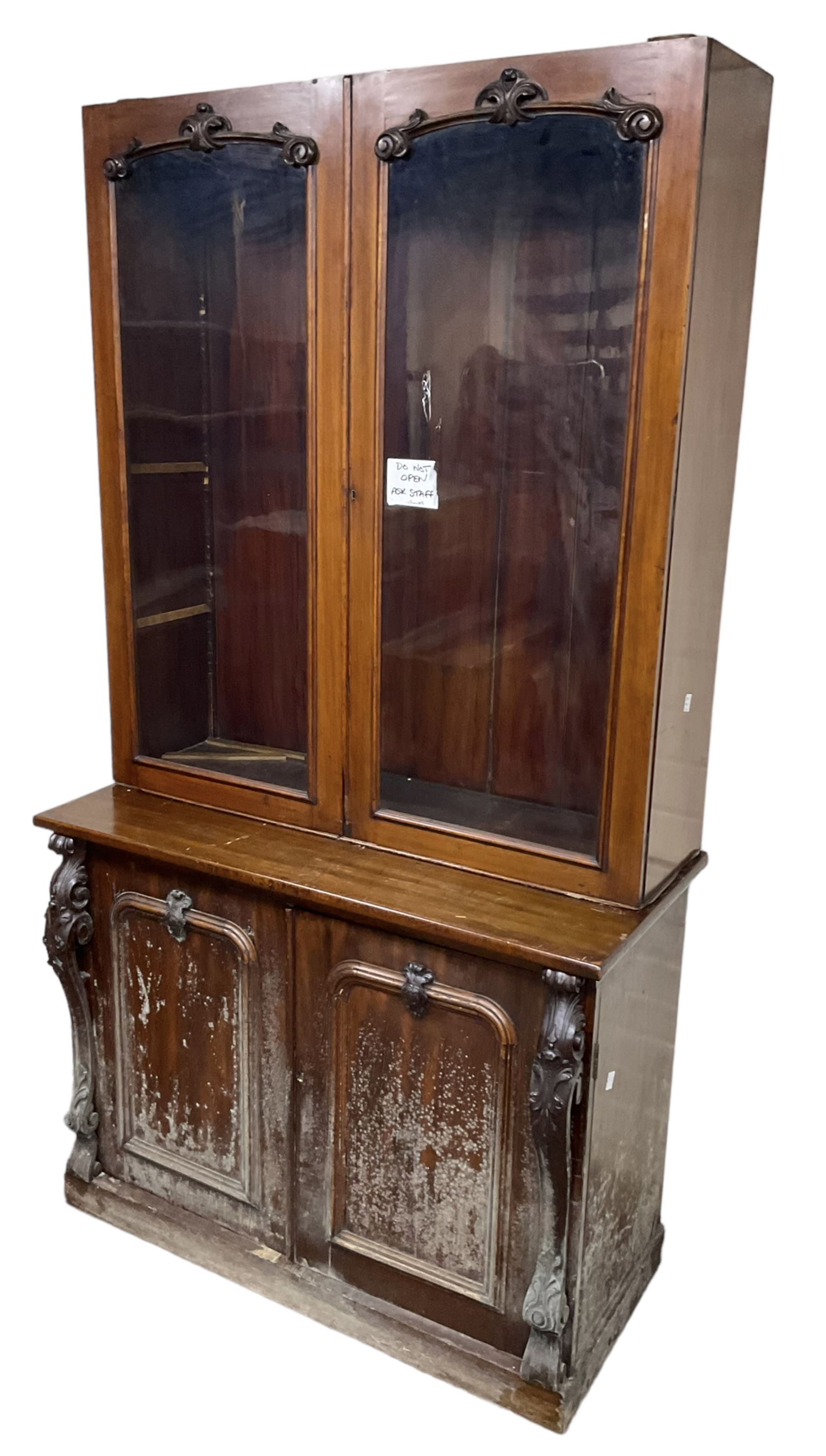 Victorian mahogany bookcase on cupboard, enclosed by two glazed doors, the base enclosed by two panelled doors flanked by acanthus carved upright pilasters, on plinth base