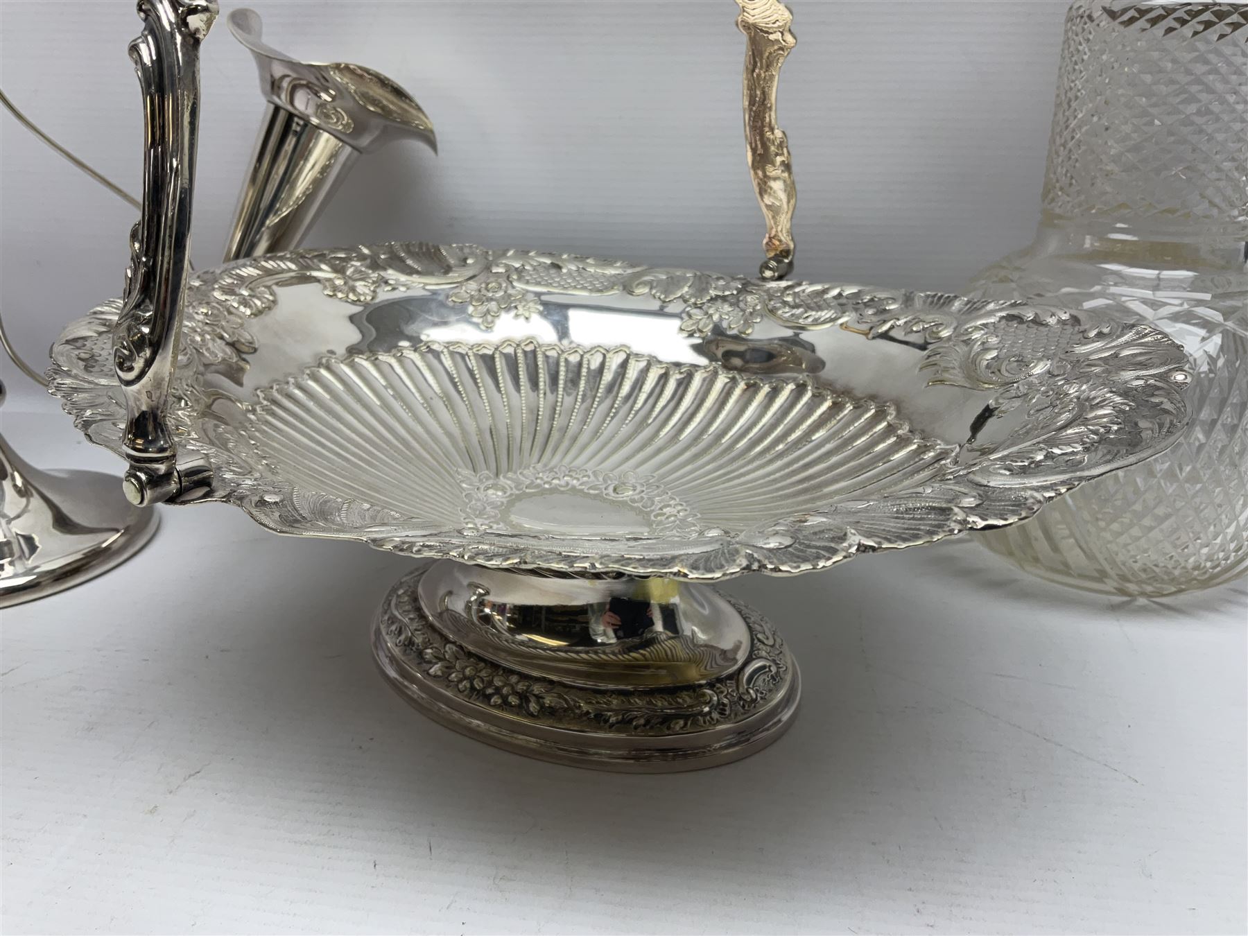 Silver plated three branch epergne, together with a silver plated cut glass claret jug, and silver plated embossed swing handled basket, epergne H30.5cm