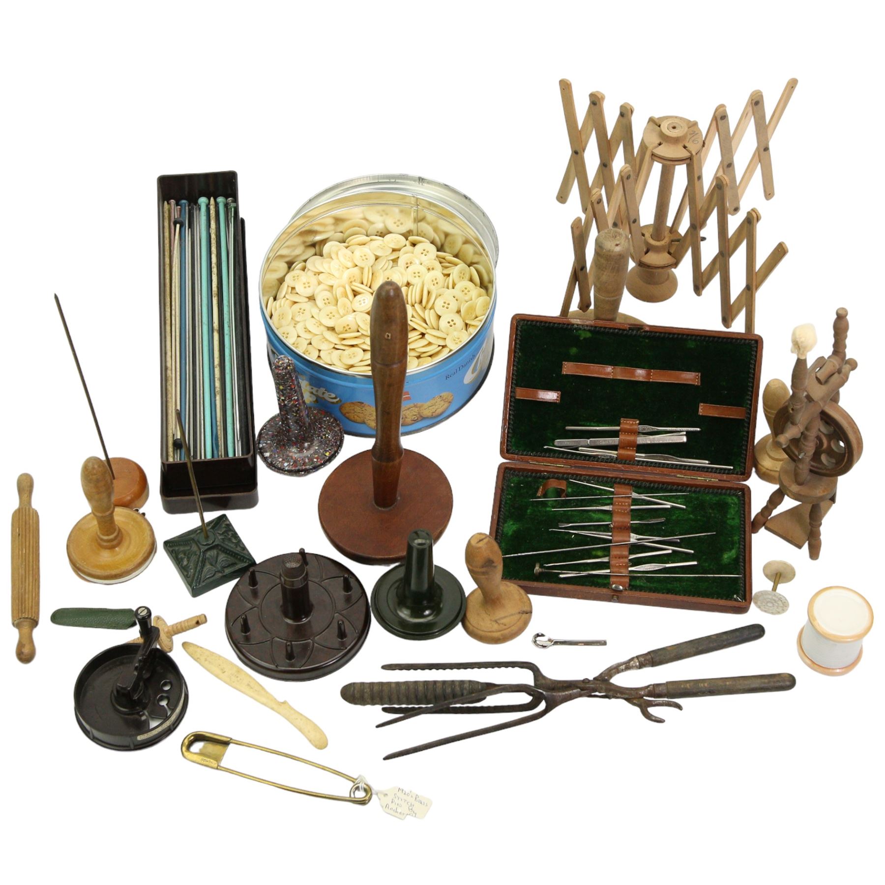 Sewing and Haberdashery Tools and Accessories to include a brass stitch pin, in the form of a paperclip, stamped Anchor, various darning mushrooms, buttons, Dewhurst's ceramic needle box, knitting needles, miniature wooden model of a spinning wheel, wool winder, bakelite wool cutter etc 