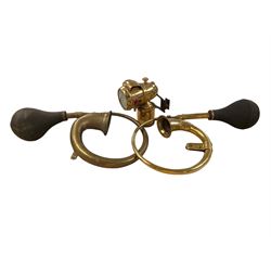 Two brass car horns and a brass bicycle lamp