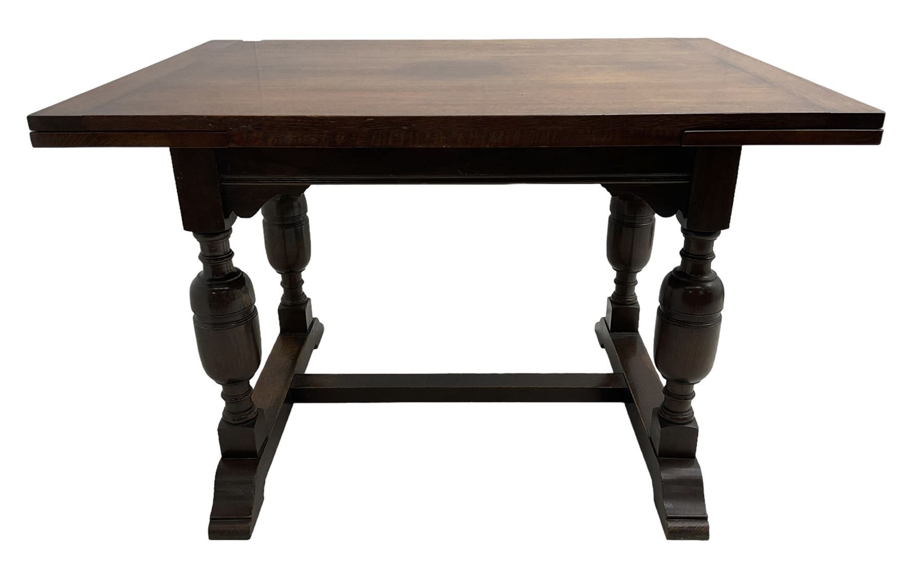 Mid-20th century medium oak dining table, rectangular draw-leaf extending top, quadruple turned pillar supports on sledge feet joined by stretcher