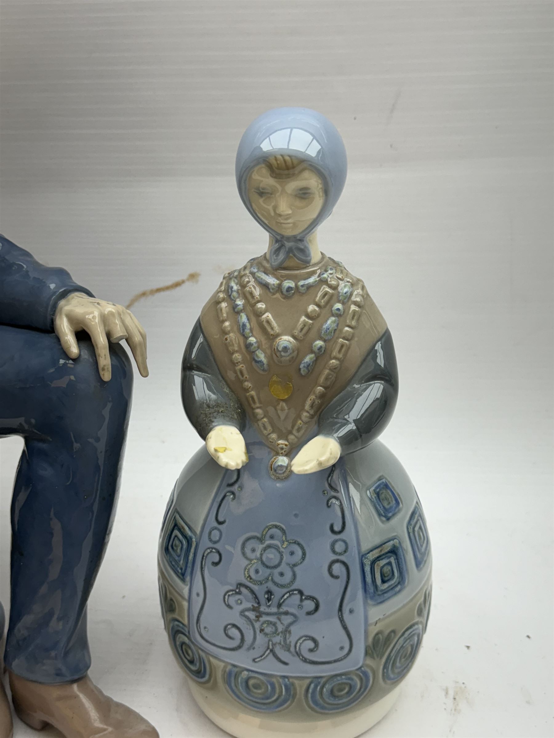 Lladro figure, Girl in Traditional Dress no 1159, together with Nao figure Old Fisherman Smoking a Pipe