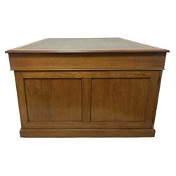 Late 19th century twin pedestal oak partner's desk, rectangular top with inset green leather writing surface, fitted with nine graduating drawers to each side, the rear drawers enclosed by panelled cupboards