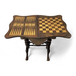 Victorian inlaid figured walnut games table, the serpentine fold-over top inlaid with scrolling foliate decoration, the top opens to reveal cribbage, backgammon and chess boards, single drawer over sliding storage well, on twin pillar supports united by double turned stretchers, on foliage carved out-splayed supports with brass and ceramic castors 