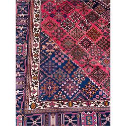 Persian Joshaghan red ground rug, the medallion, field and spandrels decorated with Pitrak and tree of life motifs, the border with repeating design decorated with stylised plant motifs, within guard stripes